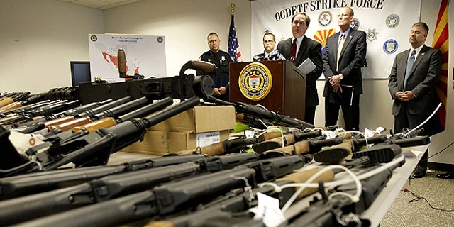 Jan. 25: United States Attorney for Arizona Dennis Burke speaks behind a cache of seized weapons in Phoenix.