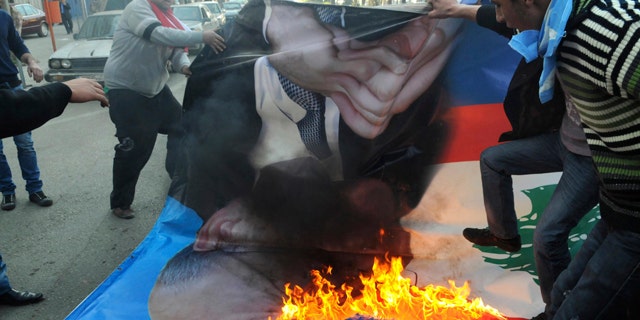 Jan. 25: Angry Sunni protesters burn a poster of former premier Najib Mikati in the northern port city of Tripoli, Lebanon.