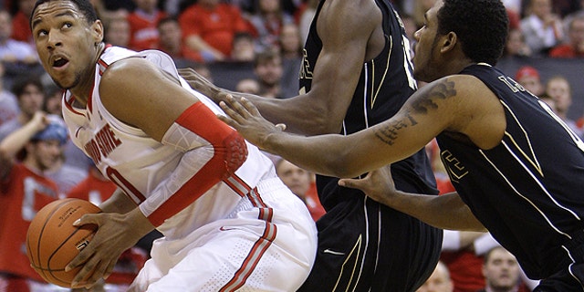 Jan. 25: Ohio State's Jared Sullinger, left, looks for an open shot against Purdue's JaJuan Johnson, center, and Terone Johnson during the second half of an NCAA college basketball game in Columbus, Ohio,