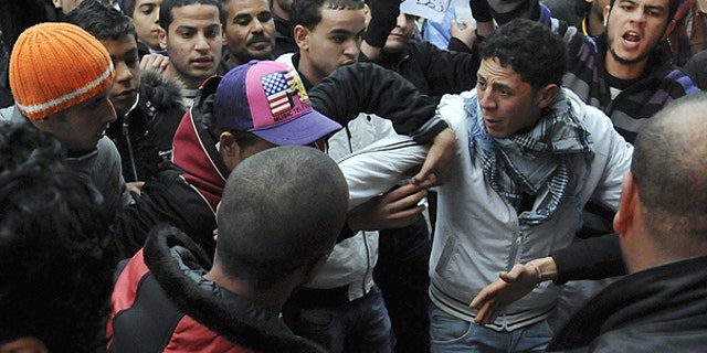 Jan. 25: Protestors supporting the government and opposed to strikes, behind, argue with demonstrators favoring the removal of ministers linked to the ousted president Zine El Abidine Ben Ali, in Tunis.