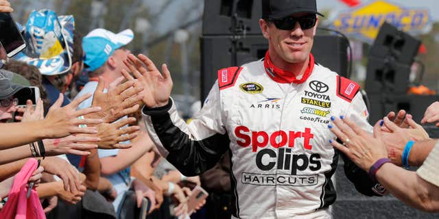 FILE - In this Oct. 30, 2016, file photo, Sprint Cup Series driver Carl Edwards (19) greets fans during driver introductions for the NASCAR Sprint Cup auto race at Martinsville Speedway in Martinsville, Va.