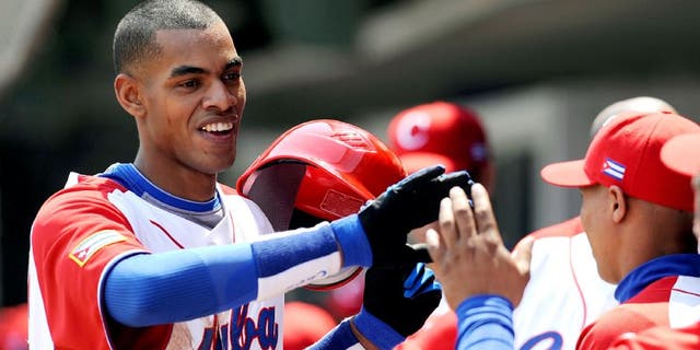 MEXICO CITY - MARCH 08: Hector Olivera #28 of Cuba is congratulated by his teammates after hitting a home run against South Africa during the 2009 World Baseball Classic Pool B match on March 8, 2009 at the Estadio Foro Sol in Mexico City, Mexico. (Photo by Kevork Djansezian/Getty Images) *** Local Caption *** Hector Olivera