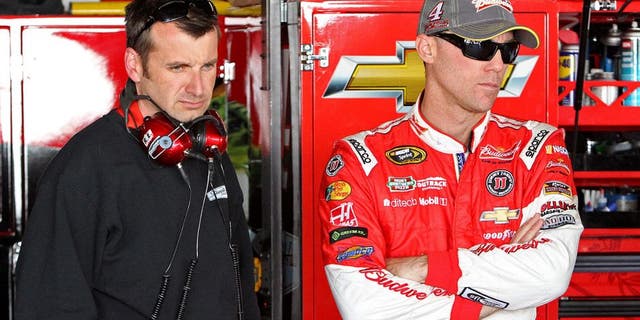 Sep 26, 2014; Dover, DE, USA; NASCAR Sprint Cup driver Kevin Harvick and NASCAR Sprint Cup Series crew chief Rodney Childers stand in the garage during practice for the AAA 400 at Dover International Speedway. Mandatory Credit: Matthew O'Haren-USA TODAY Sports