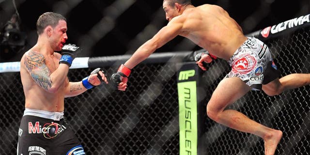 Feb 2, 2013; Las Vegas, NV, USA; Frankie Edgar (left) and Jose Aldo (right) battle each other during UFC 156 at the Mandalay Bay Events Center. Mandatory Credit: Gary A. Vasquez-USA TODAY Sports