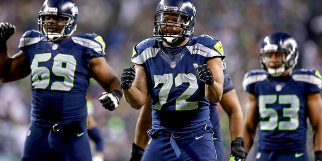 SEATTLE, WA - JANUARY 19: Defensive end Michael Bennett #72 of the Seattle Seahawks and defensive tackle Clinton McDonald #69 react against the San Francisco 49ers during the 2014 NFC Championship at CenturyLink Field on January 19, 2014 in Seattle, Washington. (Photo by Ronald Martinez/Getty Images)