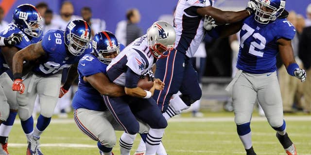 New York Giants' Mike Patterson, third from left, sacks New England Patriots quarterback Jimmy Garoppolo during the first half of an NFL preseason football game, Thursday, Aug. 28, 2014, in East Rutherford, N.J. (AP Photo/Bill Kostroun)