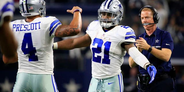 Dallas Cowboys' Dak Prescott (4) is congratulated on his touchdown run by Ezekiel Elliott (21) in the first half of an NFL football game against the Tampa Bay Buccaneers as head coach Jason Garrett, right, watches, , Sunday, Dec. 18, 2016, in Arlington, Texas. (AP Photo/Ron Jenkins)