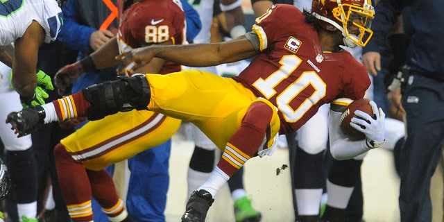 Washington Redskins quarterback Robert Griffin III flies through the air as he is knocked out of bounds during the first half of an NFL wild card playoff football game against the Washington Redskins in Landover, Md., Sunday, Jan. 6, 2013. (AP Photo/Richard Lipski)
