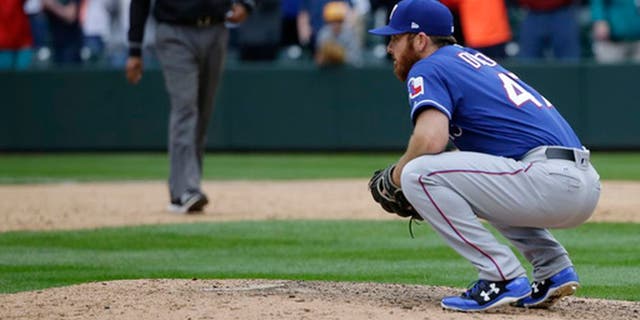 Texas Rangers closing pitcher Sam Dyson crouches on the mound after he gave up a walk-off RBI single to Seattle Mariners' Nelson Cruz in the ninth inning of a baseball game, Sunday, April 16, 2017, in Seattle. The Mariners won, 8-7. (AP Photo/Ted S. Warren)