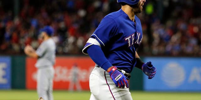 Texas Rangers' Joey Gallo jogs home after hitting a solo home run off Kansas City Royals starting pitcher Nathan Karns, rear, during the fifth inning of a baseball game in Arlington, Texas, Friday, April 21, 2017. The homer was Gallo's second of the game. (AP Photo/Tony Gutierrez)