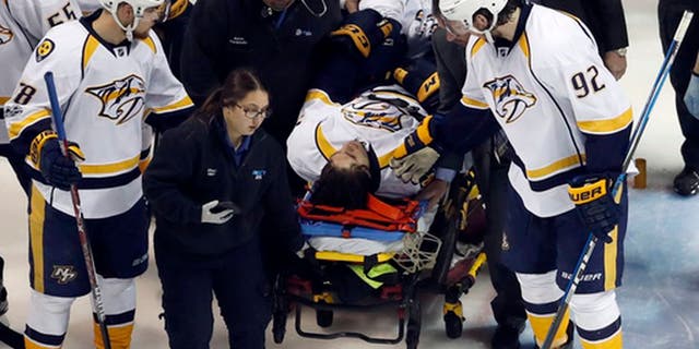 Nashville Predators' Ryan Johansen (92) and Viktor Arvidsson, left, of Sweden, offer encouragement to teammate Kevin Fiala, of Switzerland, as Fiala is taken off on a stretcher after being injured during the second period in Game 1 of an NHL hockey second-round playoff series against the St. Louis Blues, Wednesday, April 26, 2017, in St. Louis. (AP Photo/Jeff Roberson)