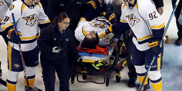Nashville Predators' Ryan Johansen (92) and Viktor Arvidsson, left, of Sweden, offer encouragement to teammate Kevin Fiala, of Switzerland, as Fiala is taken off on a stretcher after being injured during the second period in Game 1 of an NHL hockey second-round playoff series against the St. Louis Blues, Wednesday, April 26, 2017, in St. Louis. (AP Photo/Jeff Roberson)
