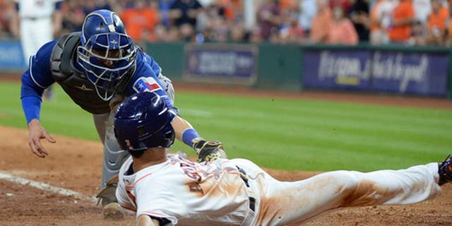 Houston Astros' Norichika Aoki slides safely into home before the tag by Texas Rangers catcher Jonathan Lucroy during the sixth inning of a baseball game Wednesday May 3, 2017, in Houston. (AP Photo/George Bridges)