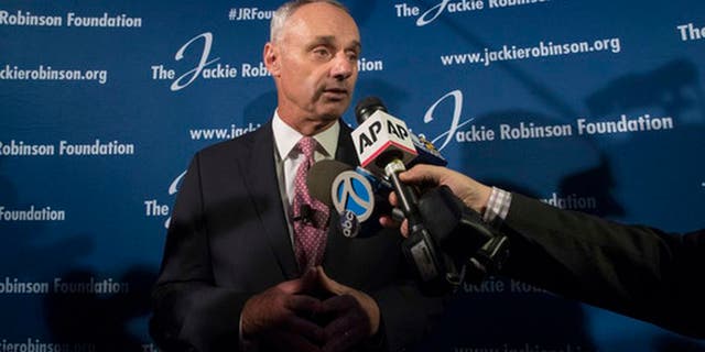 FILE - In this April 27, 2017, file photo, Major League Baseball Commissioner Rob Manfred speaks to reporters after a ceremonial ground breaking for the Jackie Robinson Museum in New York. Days after a fan at Fenway Park directed racial slurs at Baltimore Orioles outfielder Adam Jones, Manfred said he is determined to "provide our players with an environment where they feel comfortable in every major league stadium that they play." (AP Photo/Mary Altaffer, File)