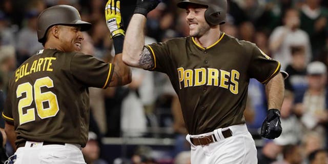 San Diego Padres' Matt Szczur, right, is greeted by Yangervis Solarte after hitting a home run during the seventh inning of the team's baseball game against the Kansas City Royals on Friday, June 9, 2017, in San Diego. (AP Photo/Gregory Bull)