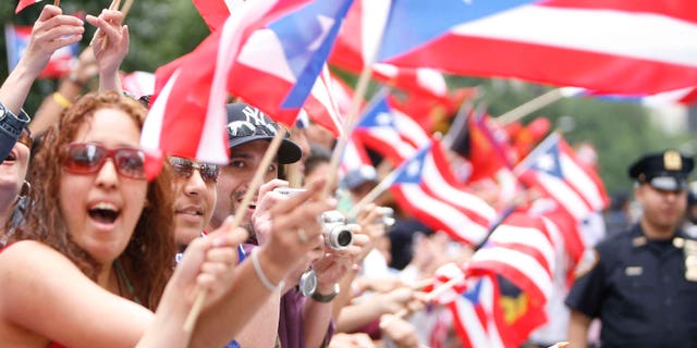 People wave flags during the 50th Anniversary of the National Puerto Rican Day Parade along 5th Avenue in 2007.