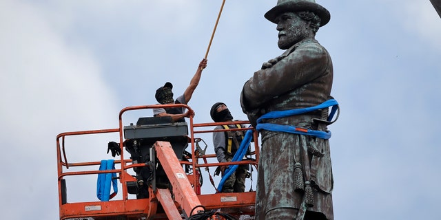 In this May 19, 2017, file photo, workers prepare to take down the statue of former Confederate general Robert E. Lee, which stands over 100 feet tall, in Lee Circle in New Orleans.