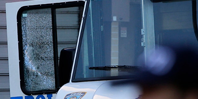 An NYPD vehicle with a cracked window sits on the scene where a police officer was shot and killed in the Bronx, New York, on Wednesday.