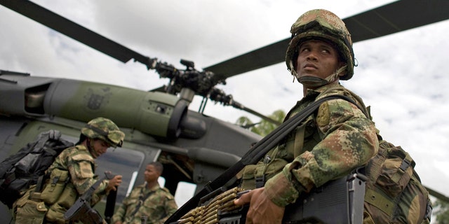 Soldiers board a helicopter in Guerima, in the eastern province of Vichada, Colombia, Wednesday March 9, 2011.  (AP Photo/William Fernando Martinez)