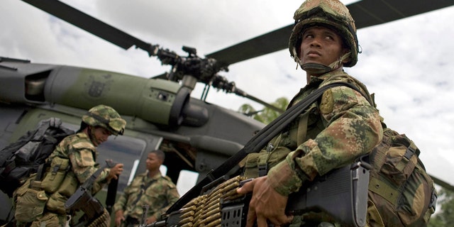 Soldiers board a helicopter in Guerima, in the eastern province of Vichada, Colombia, Wednesday March 9, 2011. (AP Photo/William Fernando Martinez)