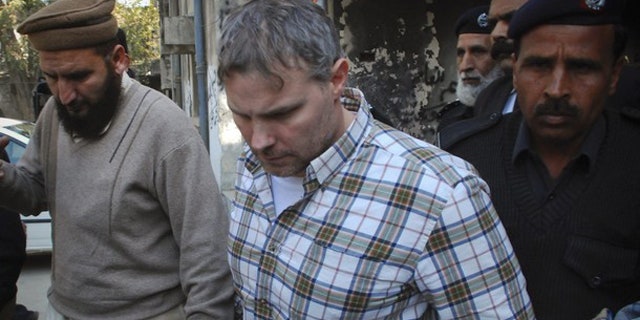 Jan. 28: A U.S. consulate employee is escorted by police and officials out of court after facing a judge in Lahore.