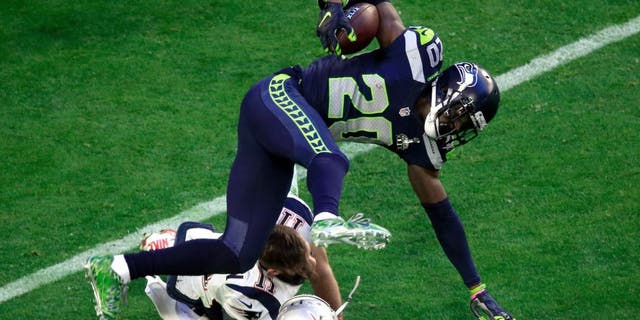 GLENDALE, AZ - FEBRUARY 01: Julian Edelman #11 of the New England Patriots tackles Jeremy Lane #20 of the Seattle Seahawks after an interception in the first quarter during Super Bowl XLIX at University of Phoenix Stadium on February 1, 2015 in Glendale, Arizona. (Photo by Jamie Squire/Getty Images)