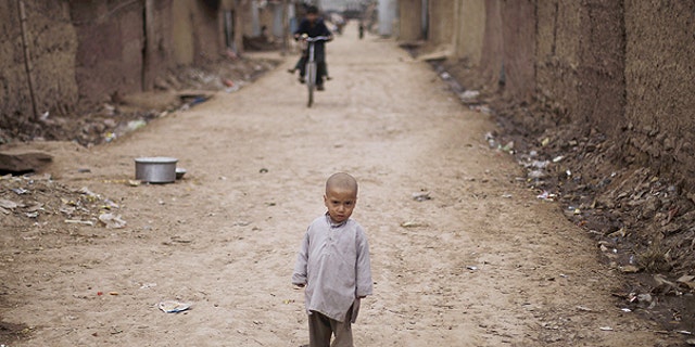 Feb. 3: A young Afghan refugee boy looks on as he stands in an alley in a slum on the outskirts of Islamabad, Pakistan.