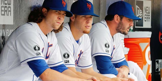 NEW YORK, NY - AUGUST 03: (L-R) Jacob deGrom #48, Zack Wheeler #45 and Matt Harvey #33 of the New York Mets look on against the San Francisco Giants at Citi Field on August 3, 2014 in the Flushing neighborhood of the Queens borough of New York City. The Giants defeated the Mets 9-0. (Photo by Jim McIsaac/Getty Images)