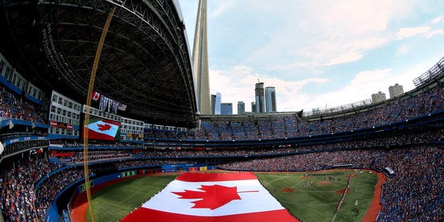 TORONTO, CANADA - JULY 1: A general view of the Rogers Centre on Canada Day as a large Canadian flag is unfurled on the field during the singing of the Canadian anthem before the start of the Toronto Blue Jays MLB game against the Milwaukee Brewers on July 1, 2014 at Rogers Centre in Toronto, Ontario, Canada. (Photo by Tom Szczerbowski/Getty Images)