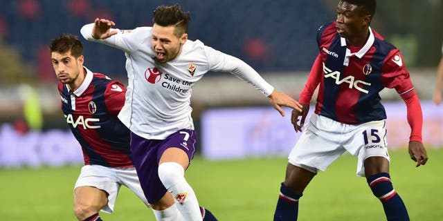 Fiorentina's forward from Argentina Mauro Zarate (C) fights for the ball with Bologna's defender from Senegal Ibrahima Mbaye and Bologna's forward from Italy Franco Brienza (L) during the Italian Serie A football match Bologna vs Fiorentina at "Renato Dall'Ara" Stadium in Bologna on Febrauary 6, 2016. / AFP / GIUSEPPE CACACE (Photo credit should read GIUSEPPE CACACE/AFP/Getty Images)