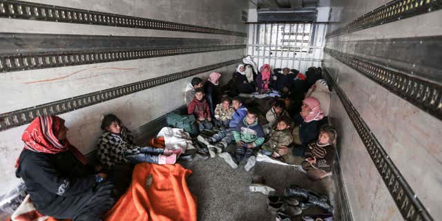 FEb. 6, 2016: Syrians gather inside a truck to protect themselves from the cold weather at the Bab al-Salam border gate with Turkey, in Syria.