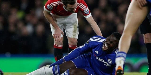 Chelsea's French defender Kurt Zouma clutches his knee during the English Premier League football match between Chelsea and Manchester United at Stamford Bridge in London on February 7, 2016. / AFP / ADRIAN DENNIS / RESTRICTED TO EDITORIAL USE. No use with unauthorized audio, video, data, fixture lists, club/league logos or 'live' services. Online in-match use limited to 75 images, no video emulation. No use in betting, games or single club/league/player publications. / (Photo credit should read ADRIAN DENNIS/AFP/Getty Images)