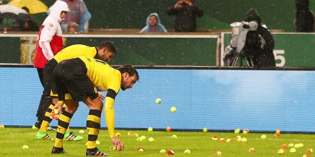STUTTGART, GERMANY - FEBRUARY 09: Players remove tennis balls thrown by Dortmund fans from the pitch during the DFB Cup Quarter Final match between VfB Stuttgart and Borussia Dortmund at Mercedes-Benz Arena on February 9, 2016 in Stuttgart, Germany. (Photo by Alex Grimm/Bongarts/Getty Images)