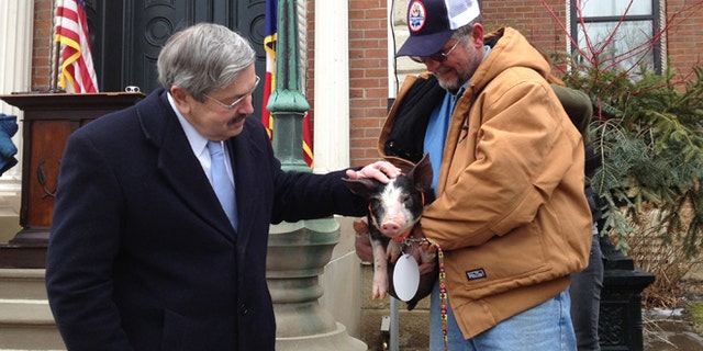 Feb. 8, 2013: Iowa Gov. Terry Branstad, left, pardons a Berkshire pig named Bonnie, held by her owner Randy Hilleman, at the governor's mansion in Des Moines, Iowa.