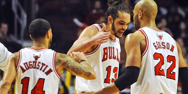 Feb 11, 2014; Chicago, IL, USA; Chicago Bulls point guard D.J. Augustin (14), Chicago Bulls center Joakim Noah (13) and Chicago Bulls power forward Taj Gibson (22) celebrate scoring in the second half against the Atlanta Hawks at the United Center. The Bulls beat the Hawks 100-85. Mandatory Credit: Matt Marton-USA TODAY Sports
