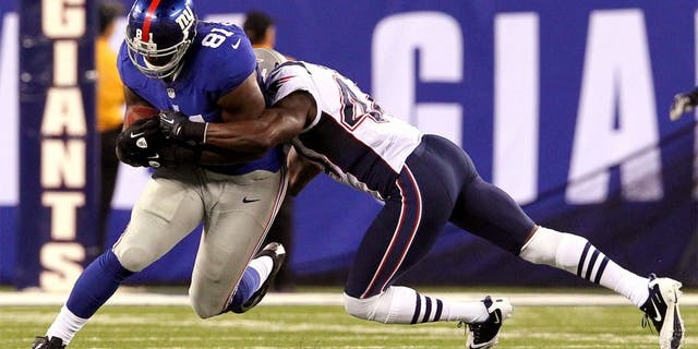 August 29, 2012; East Rutherford, NJ, USA; New York Giants tight end Adrien Robinson (81) is brought down by New England Patriots defensive back James Ihedigbo (44) during the third quarter of a preseason game at MetLife Stadium. Mandatory Credit: Brad Penner-USA TODAY Sports