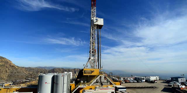 FILE - In this Dec. 9, 2015, pool file photo, crews work on stopping a gas leak at a relief well at the Aliso Canyon facility above the Porter Ranch area of Los Angeles.