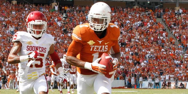 Oct 12, 2013; Dallas, TX, USA; Texas Longhorns wide receiver Mike Davis (1) scores a touchdown while being defended by Oklahoma Sooners defensive back Zack Sanchez (15) at the Red River Rivalry at Cotton Bowl Stadium. The Texas Longhorns beat the Oklahoma Sooners 36-20. Mandatory Credit: Tim Heitman-USA TODAY Sports