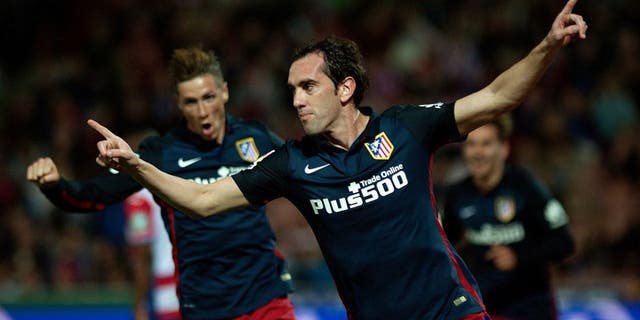 Atletico Madrid's Uruguayan defender Diego Godin (R) celebrates a goal during the Spanish league football match Granada FC VS Club Atletico de Madrid at Nuevo Los Carmenes stadium in Granada on December 5, 2015. AFP PHOTO / JORGE GUERRERO / AFP / Jorge Guerrero (Photo credit should read JORGE GUERRERO/AFP/Getty Images)