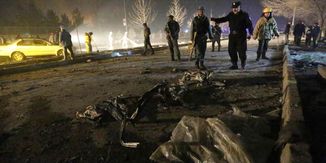 FILE - In this Jan. 20, 2016 file photo, Afghan security forces inspect the site of a suicide attack near the Russian embassy in Kabul, Afghanistan.
