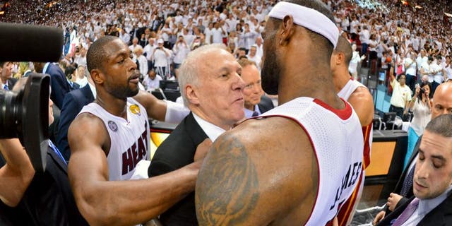 MIAMI, FL - JUNE 20: LeBron James #6 and Dwyane Wade #3 of the Miami Heat hug Head Coach Gregg Popovich of the San Antonio Spurs following the Heat's victory against the Spurs in Game Seven of the 2013 NBA Finals on June 20, 2013 at American Airlines Arena in Miami, Florida. NOTE TO USER: User expressly acknowledges and agrees that, by downloading and or using this photograph, User is consenting to the terms and conditions of the Getty Images License Agreement. Mandatory Copyright Notice: Copyright 2013 NBAE (Photo by Jesse D. Garrabrant/NBAE via Getty Images)