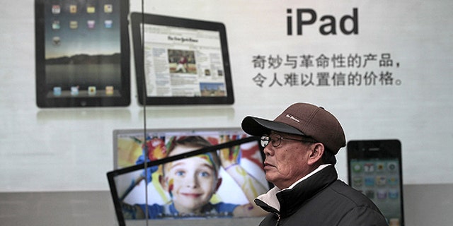 Jan. 26: A man stands near Apple's iPad advertisement in Shanghai, China.