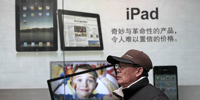 Jan. 26: A man stands near Apple's iPad advertisement in Shanghai, China.