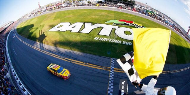 DAYTONA BEACH, FL - FEBRUARY 22: Joey Logano, driver of the #22 Shell Pennzoil Ford, takes the checkered flag to win the NASCAR Sprint Cup Series 57th Annual Daytona 500 at Daytona International Speedway on February 22, 2015 in Daytona Beach, Florida. (Photo by Jonathan Ferrey/NASCAR via Getty Images)