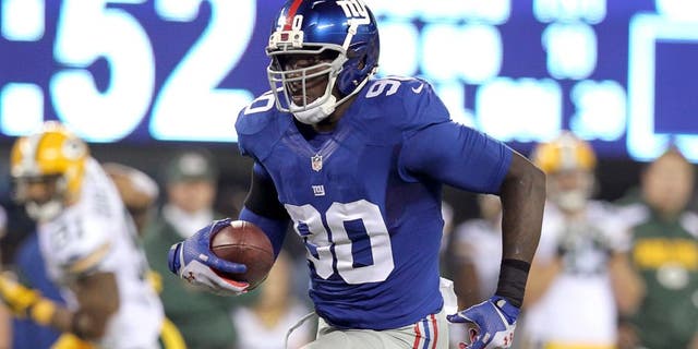 Nov 17, 2013; East Rutherford, NJ, USA; New York Giants defensive end Jason Pierre-Paul (90) runs back an interception against the Green Bay Packers for a touchdown during the fourth quarter of a game at MetLife Stadium. Mandatory Credit: Brad Penner-USA TODAY Sports