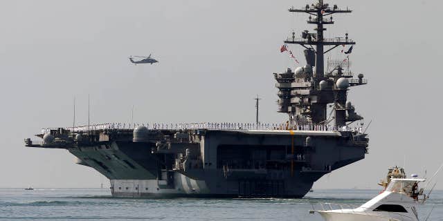 FILE - In this Aug. 22, 2014 file photo, the aircraft carrier USS Carl Vinson sails out of San Diego Harbor leaving for a nine month deployment in San Diego.