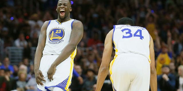 Golden State Warriors' Draymond Green, left, and Shaun Livingston, right, celebrate a 3-pointer by teammate Harrison Barnes, not seen, during the second half of an NBA basketball game against the Los Angeles Clippers, Saturday, Feb. 20, 2016, in Los Angeles. The Warriors won 115-112. (AP Photo/Danny Moloshok)