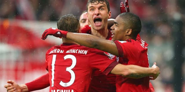 MUNICH, GERMANY - FEBRUARY 20: Thomas Mueller (C) of Muenchen celebrates scoring the 2nd team goal with his team mates Rafinha (L) and Douglas Costa during the Bundesliga match between FC Bayern Muenchen and SV Darmstadt 98 at Allianz Arena on February 20, 2016 in Munich, Germany. (Photo by A. Hassenstein/Getty Images for FC Bayern)