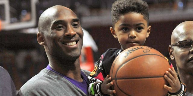 Los Angeles Lakers' Kobe Bryant left, poses with Chicago Bulls' Derrick Rose's son P.J. Rose 3, before an NBA basketball game against the Chicago Bulls, Sunday, Feb. 21, 2016, in Chicago. (AP Photo/Paul Beaty)