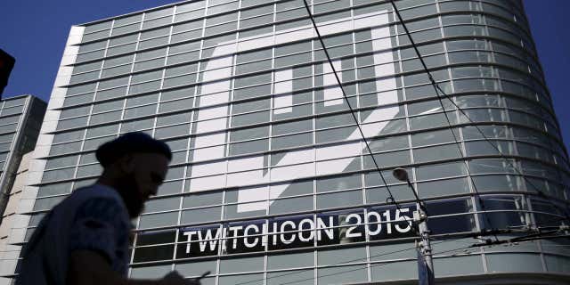 Sept. 25, 2015: A man works with a mobile device prior to entering TwitchCon 2015 in San Francisco.